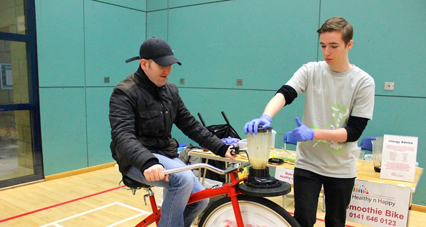 Image of a man powering a smoothie bike in a leisure centre.